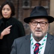 George Galloway, with his wife Putri Gayatri Pertiwi, speaks to the media outside the Houses of Parliament in Westminster