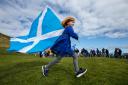 All Under One Banner march for independence, Arbroath. A young girl runs with a saltire flag at Victoria Park, Arbroath at the end of the march...Photograph by Colin Mearns.Saturday 2 April 2022.