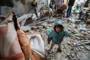 People inspect damage and recover items from their homes following Israeli air strikes