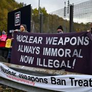 Anti-nuclear campaigners hold banners and placards outside Her Majesty's Naval Base, Clyde