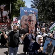 Palestinians hold photographs of prisoners jailed in Israel and posters depicting Israeli Prime Minister Benjamin Netanyahu and U.S. President Joe Biden, during a rally marking the annual prisoners' day in the West Bank city of Nablus