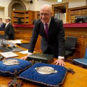 John Swinney stands with the Seals of Scotland as he is sworn in