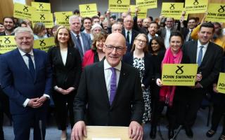 John Swinney poses with supporters as he launches his SNP leadership bid on May 2, 2024