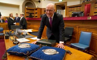 John Swinney stands with the Seals of Scotland as he is sworn in