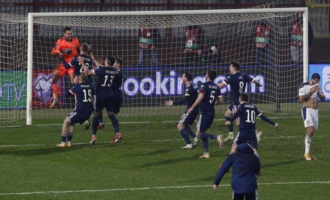 David Marshall is hoisted to the heavens by his Scotland teammates after his penalty shootout heroics.