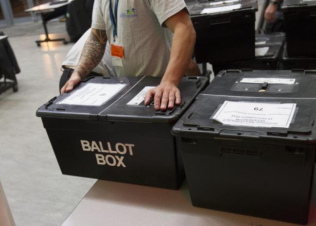 Ballot boxes at polling stations are fitted with security tags before voting starts