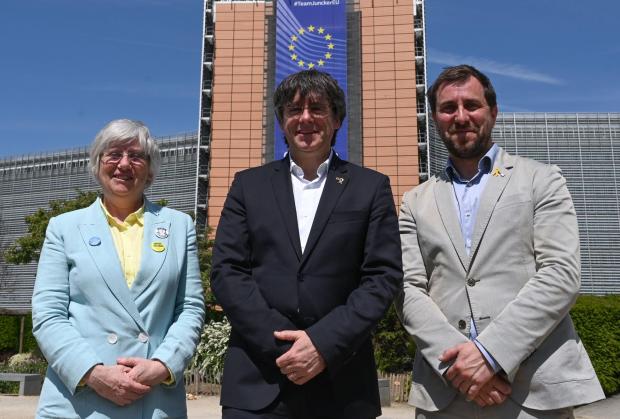 The National: Former Catalan premier Carles Puigdemont (centre) poses with Clara Ponsati and Toni Comin in front of the European Commission headquarters in Brussels