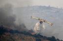 An airplane drops water over a fire in the village of Gavalas, on the Greek island of Evia. Photo: Thanassis Stavrakis