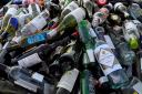General view of a bottle bank overflowing at a recycling area in Brentford, London..