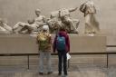 Visitors admire the sculpture of the ancient Greek Parthenon Marbles in the British Museum