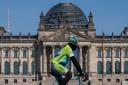 A mask-clad cyclist passes the Reichstag building in Berlin