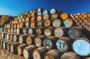 A mountain of whisky casks in store at a cooperage. Photo by Brian Taylor on Unsplash