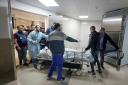 Journalists and medics wheel the body of Shireen Abu Akleh, a journalist for Al-Jazeera, into a morgue at a hospital in the West Bank