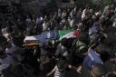 Palestinian militants carry the body of Shireen Abu Akleh, a journalist for Al Jazeera network, on May 11, two days before her funeral. Photo: AP/Majdi Mohammed