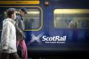 People walking past a ScotRail train.