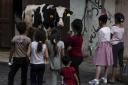 Children look at a cow on the first day of Eid al-Adha in Gaza