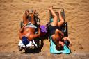 People enjoy the high temperatures on a beach as 40C weather could be on the way. Photo: PA