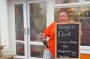 Jaki Pickett holds a sign reading 'Lizard Liz is dead' outside her Highland chippy