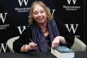 Hilary Mantel, who has died aged 70, signing a copy of her last novel The Mirror and the Light