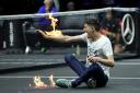 A protester lights his arm on fire on the court on day one of the Laver Cup