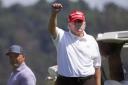 Donald Trump lifts a closed fist on a gold course in Sterling, Virginia last month