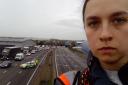 A protester who has climbed a gantry on the M25 between junctions six and seven in Surrey