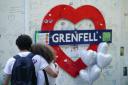 Members of the public at the memorial at the base of Grenfell Tower in London