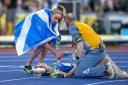 Eilish McColgan tries to help Eloise Walker after she collapsed on the line in the 5,000m at the Commonwealth Games