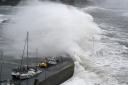 Waves crash over the harbour wall at Stonehaven