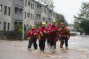Emergency service workers walk through flood water in Brechin after Storm Babet