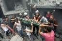 Palestinians carry a dead person who was found in the debris following Israeli airstrikes on Gaza City