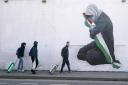People walk past a pro-Palestine mural by the artist Emmalene Blake in the Harold's Cross area of Dublin