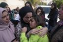 Women cry while they take the last look at the body of Ayham Shafe, during his funeral in the West Bank city of Ramallah