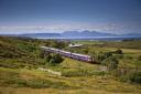 Super Sprinter train passes islands of Eigg and Rhum on the Fort William to Mallaig Line