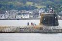 A Royal Navy Vanguard class nuclear submarine returning to Faslane seen covered in sea growth and with missing exterior tiles