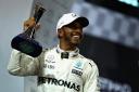 Second place finisher Lewis Hamilton celebrates with his trophy during the Abu Dhabi Formula One Grand Prix at Yas Marina Circuit