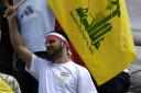 A protester flies a Hezbollah flag in Trafalgar Square in London (Andrew Stuart/PA)