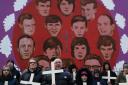 People stop at a mural of the victims of Bloody Sunday during the annual march on the 50th anniversary of Bloody Sunday. Photo: PA