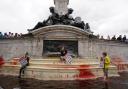 Animal Rebellion protesters stand in the fountain at the Queen Victoria Memorial, which they have covered in red paint