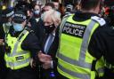 Prime Minister Boris Johnson is surrounded by police as he arrives at Glasgow Central station for a second visit to COP26