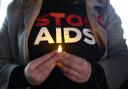 A woman holds a candle at a World Aids Day event