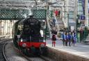 Piper Kevin MacDonald from the Red Hot Chilli Pipers with schoolchildren from the Royal Scottish Country Dance Society, during an event at Edinburgh Waverley station to mark the day the world famous locomotive, Flying Scotsman, entered service on
