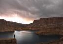 A man stands and admires Band-e Amir National Park in Afghanistan