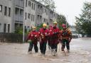 Emergency service workers walk through flood water in Brechin after Storm Babet