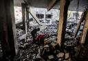 People search through buildings, destroyed during Israeli air raids in the southern Gaza Strip