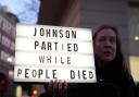 A woman protests after the arrival of former British Prime Minister Boris Johnson at the Covid Inquiry