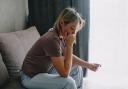 A stock image of a woman checking a pregnancy test