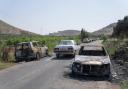 Torched vehicles are seen along the road in the West Bank village of al-Mughayyir (AP Photo/Nasser Nasser)