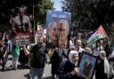 Palestinians hold photographs of prisoners jailed in Israel and posters depicting Israeli Prime Minister Benjamin Netanyahu and U.S. President Joe Biden, during a rally marking the annual prisoners' day in the West Bank city of Nablus