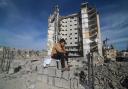 A Palestinian boy sits outside a residential building destroyed in an Israeli strike in Rafah, Gaza Strip